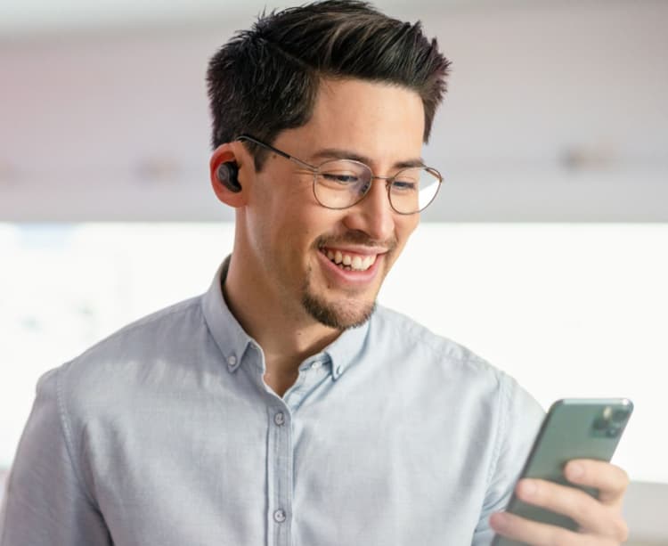 Ein Mann mit Kopfhörern und Smartphone.