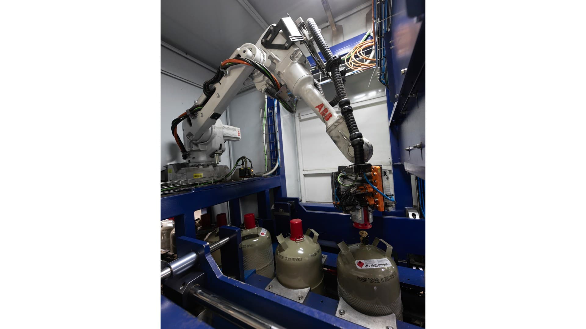 Ein ABB-Roboter IRB 2600 entfernt Ventilschutzkappen von Propangasflaschen.