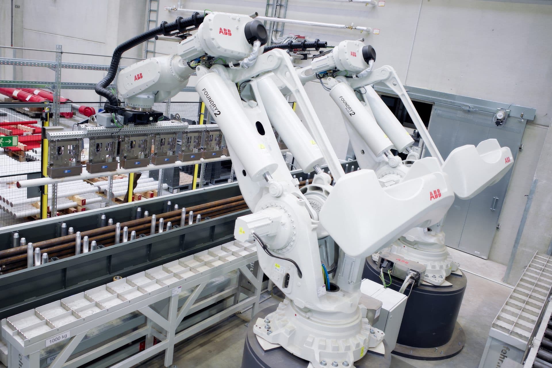 Zwei ABB-Sechsachsroboter IRB 8700 beim automatisierten Handling schwerer Lasten in einer Industrieanlage.