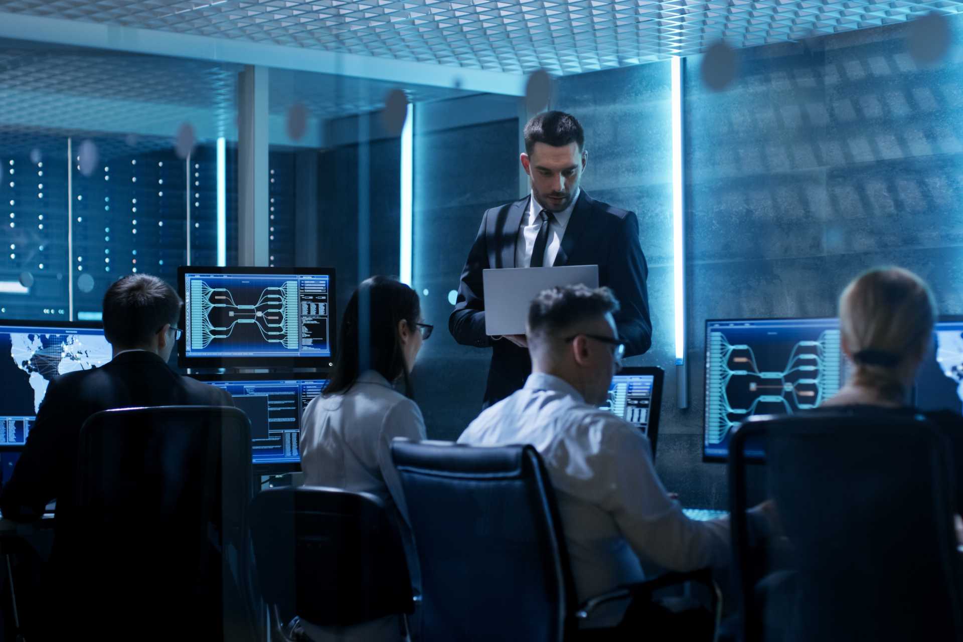 Workers watching screens near server room