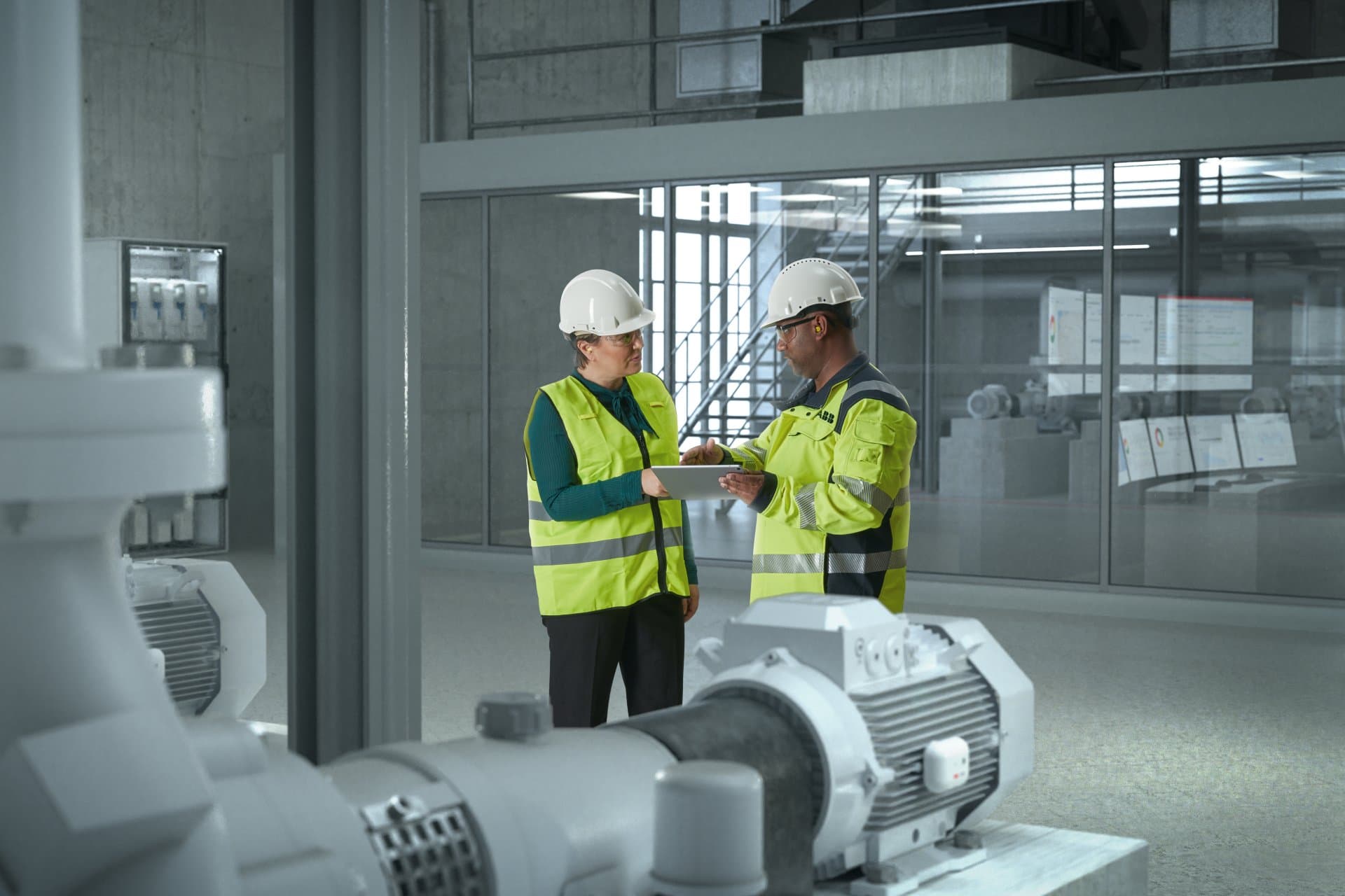 Header Symbolbild einer Produktionshalle mit E-Motor und zwei Plant Manager mit einem Klemmbrett.