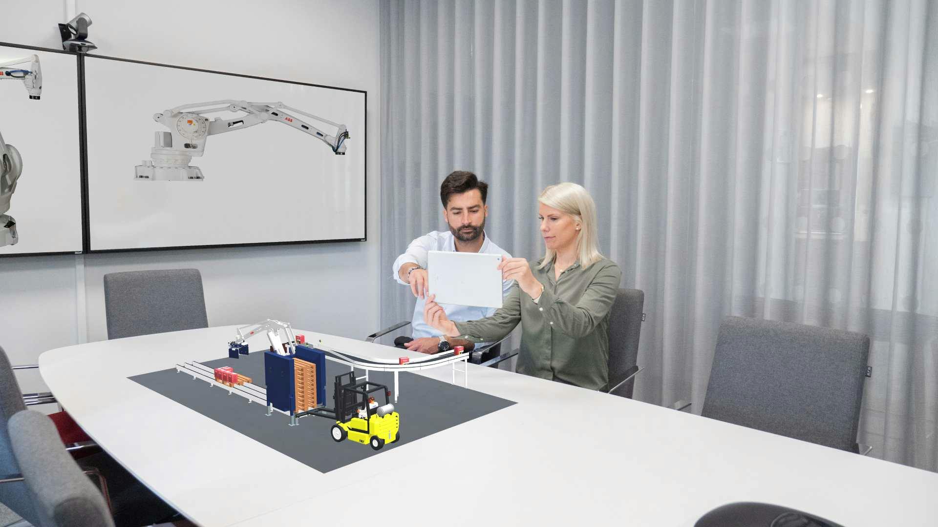 Ein digitaler Zwilling eines Verpackungsroboters wird auf einen Konferenztisch projiziert.